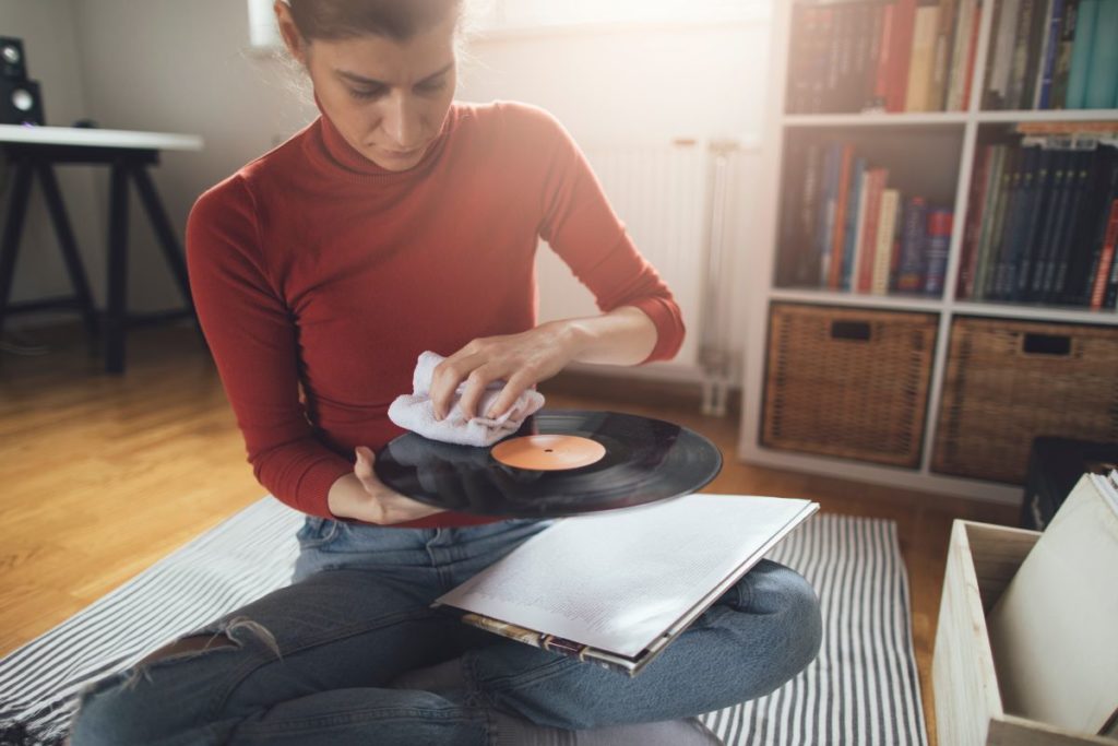 Person cleaning a vinyl record