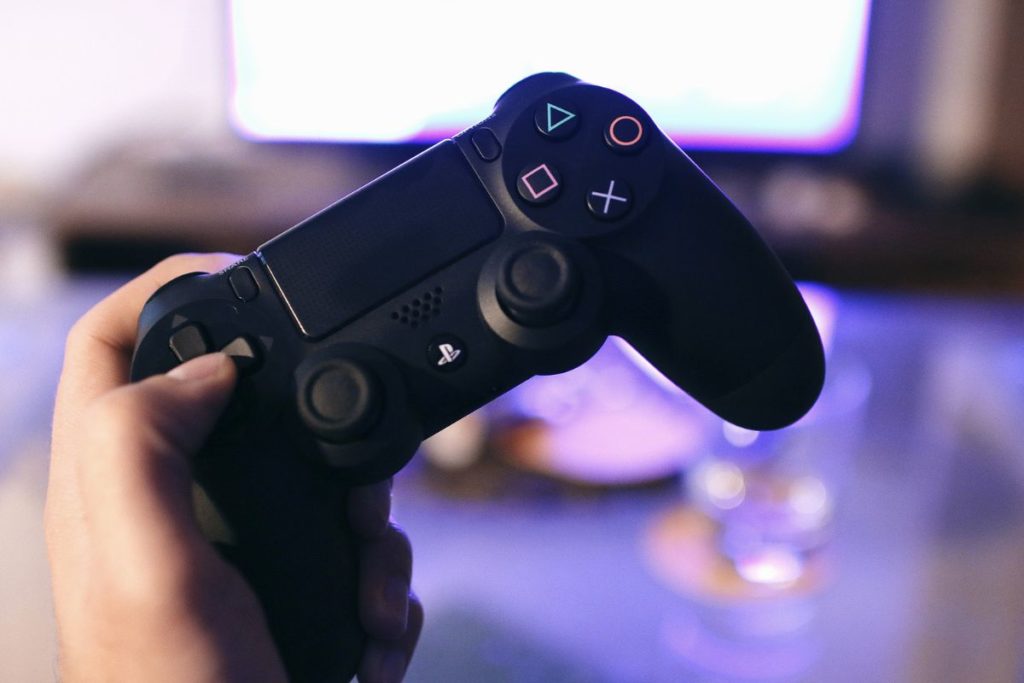 Person holding a PS4 controller