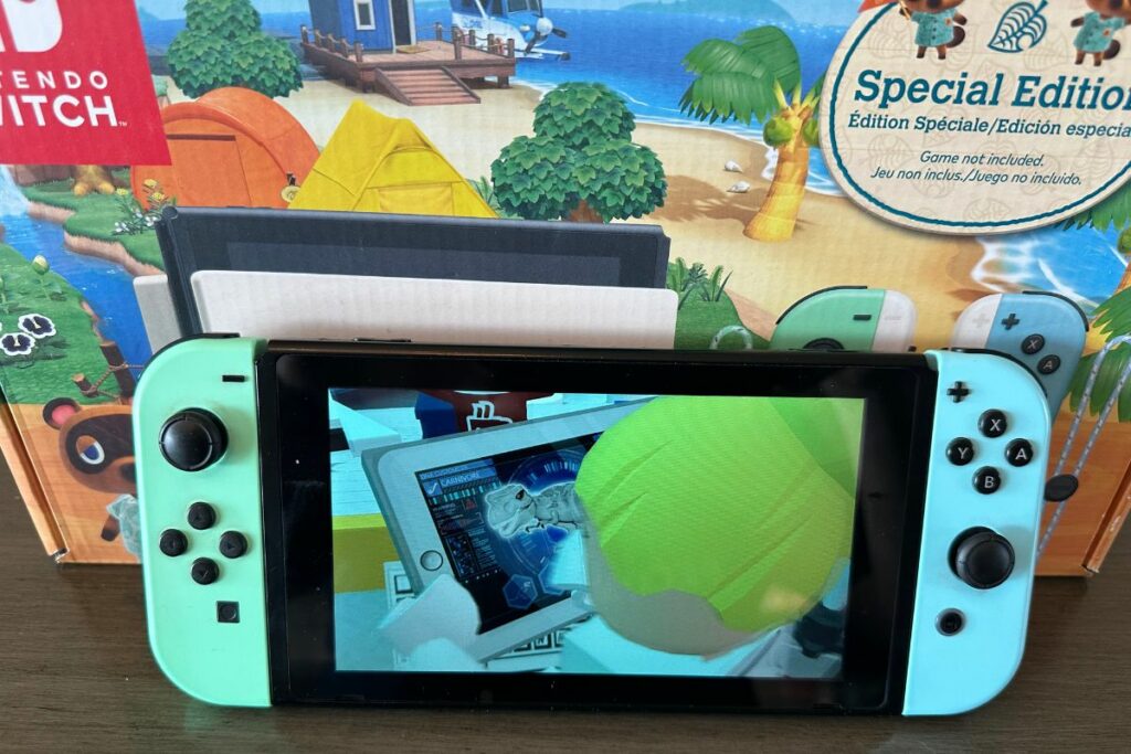 Nintendo Switch with the screen turned on in front of Animal Crossing Box